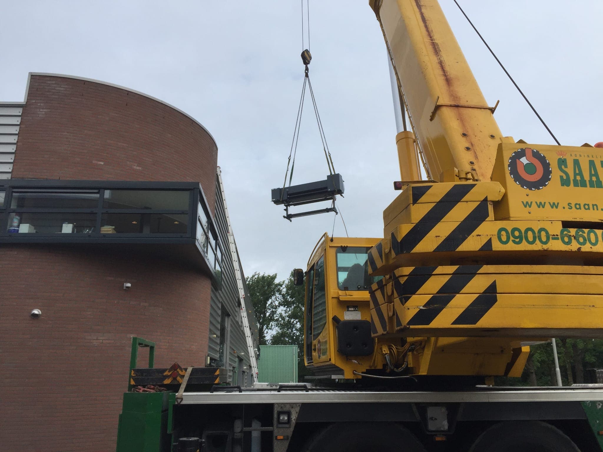 Verhuizing_naar_het_nieuwe_pand_printer_wordt_uit_het_pand_gehesen_af198dde19
